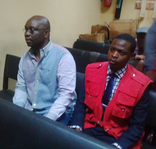 Fayose sitting beside official of EFCC official in court in Lagos