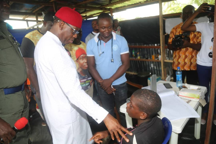 Okowa conversing with a child who is taking shelter at the flood holding camp