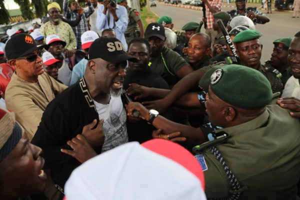 Senator Dino Melaye, with Ben Murray Bruce, at his back arguing with the police