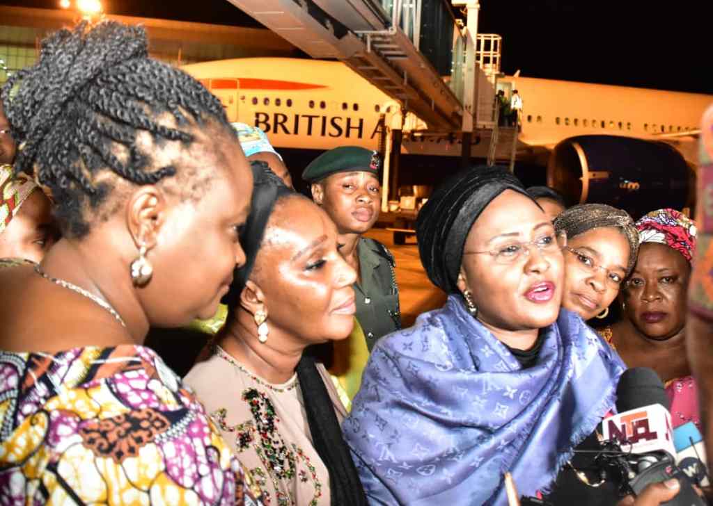 Mrs Aisha Buhari speaking with some journalists on arrival in Abuja, on Sunday